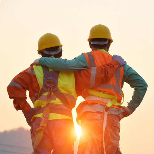 Arbeiter auf Baustelle im Gegenlicht der untergehenden Sonne