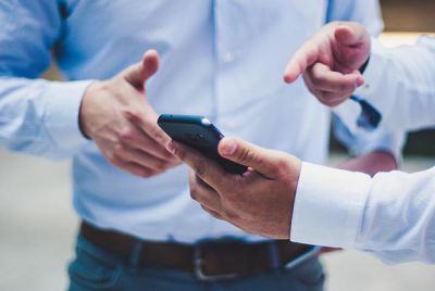 Digital supply chain in plant engineering: Two men with smartphone and app