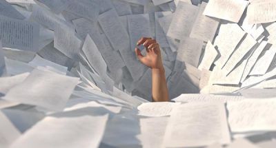 Traditional project logistics via Excel, e-mail and paper: Man drowns in data chaos - hand protrudes from mountain of paper.