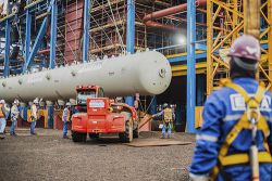 Site management in construction: Picture of construction site, team of construction workers, maschine and large installation item.